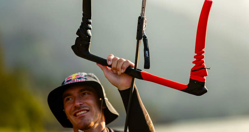 Load image into Gallery viewer, Green Hat Kiteboarding-F-One ATOM Control Bar-Live Shot-Man Wearing a Bucket Hat Holding an ATOM Bar
