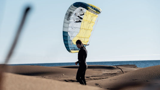 Person on a beach with Flysurfer POW2  parawing in the background