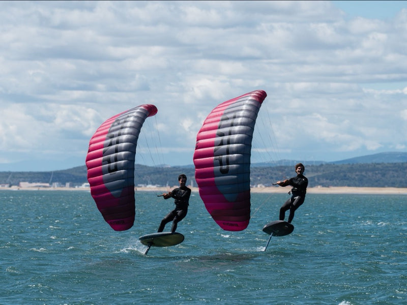 Load image into Gallery viewer, Two people parawinging over a body of water with Flysurfer ZAP Parawings.
