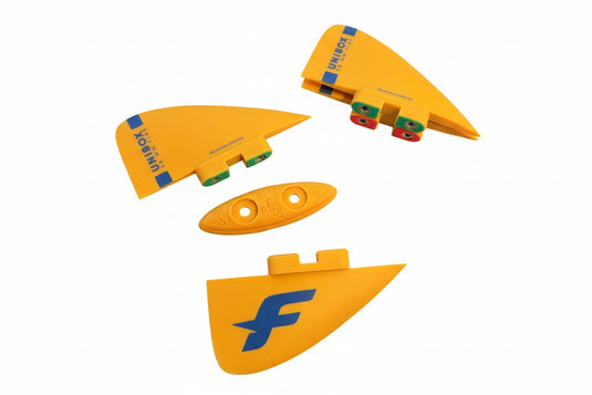 Mango colored twin tip fins on a white surface 