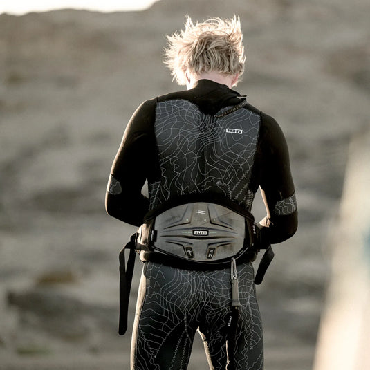 Green Hat Kiteboarding-2025 ION Riot Curv Kiteboarding Waist Harness-Live Shot-Man Wearing ION Riot Curv harness on a Beach his Back to the Camera