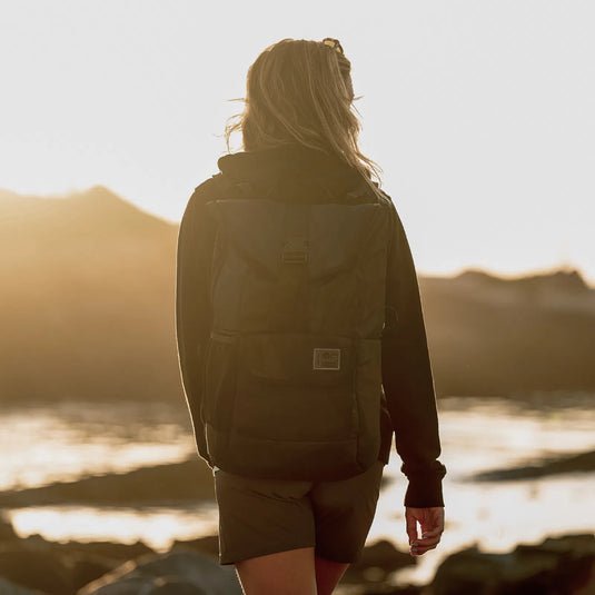 Green Hat Kiteboarding-ION Mission Pack-Black-Live Shot-Woman Walking on the Beach with ION Mission Pack