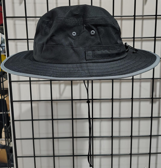 Green Hat Kiteboarding-Lift Foils Bucket Hat-Left View of Black bucket hat with a logo patch on a grid background