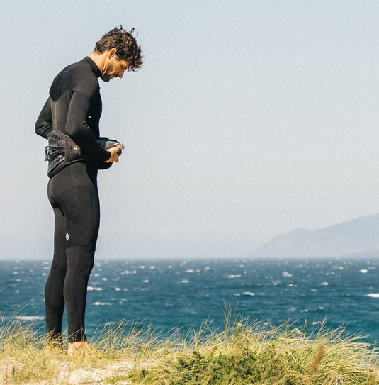 Green Hat Kiteboarding-2026 Manera X10D 3/2 Wetsuit FZ-Live Shot-Man Standing on a Dune Wearing the Manera X10D and Manera Kite Harness