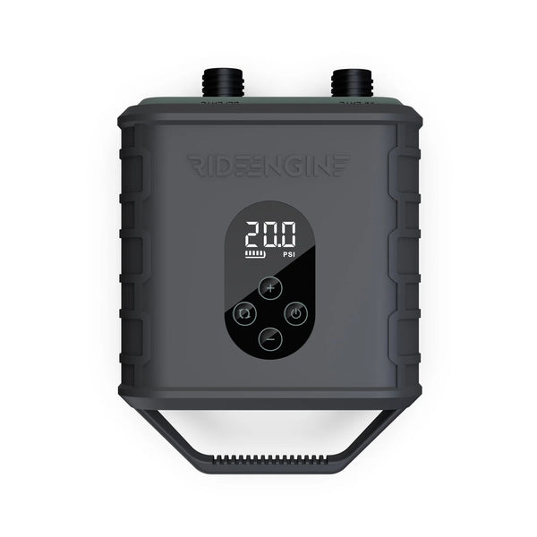 A black device with buttons and a digital display, the Ride Engine Air Box Electric Pump, used for inflating kites, wings, and boards. It has a two-stage system for fast inflation and real-time pressure monitoring. Includes Air Box, Hose (3'), 4 Nozzles, USB-C Charging Cable, 12V Car Charger.