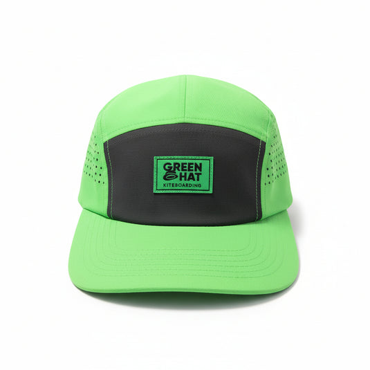 Green cap with a dark grey patch on a white surface