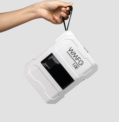 Green Hat Kiteboarding-WMFG 1.0 Electric Kite/Wing/SUP Pump-Pump with black screen and 'WMFG' branding held by a hand on a light gray background