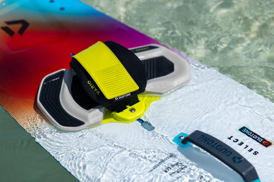 Close-up of a surfboard with a yellow leash attachment in clear water