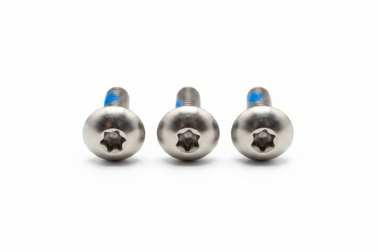Three metal screws on a white surface